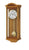 Holzfarbene Wanduhr mit rundem Zifferblatt und sichtbar aufgehängtem Pendel