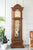Orologio a pendolo in legno con movimento a vista dietro vetro e linee decorative del pendolo