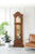 Orologio a pendolo in legno marrone con quadrante in vetro e pendolo dorato all'interno