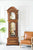 Pendola in legno con cassa curva, anta in vetro e pendolo a vista.