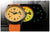 Vista orologio da uomo: quadrante giallo con cinturino arancione, orologio nero parzialmente visibile