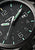 Orologio da uomo con quadrante nero, indici verdi e scritta Traser.