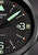 Dettaglio orologio da uomo: quadrante nero con indici luminescenti e datario "83"
