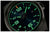 Primo piano di orologio da uomo: quadrante nero con lancette e indici luminescenti verdi.