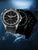 Orologio da uomo con quadrante nero e indici luminescenti verdi, cinturino in silicone nero