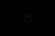 Leuchtende grüne Indexe und Zeiger einer Uhr auf dunklem Hintergrund
