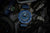Herrenarmbanduhr mit blauem Armband, blauem Lünette und grün leuchtenden Zeigern/Indexen