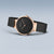 Orologio da donna visto di lato: quadrante nero, corona in oro rosa, cinturino milanese nero