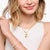 Charm a forma di sole color oro su catenina, indossato come collana