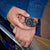 Orologio cronografo da uomo in mano con quadrante nero e cinturino mimetico.