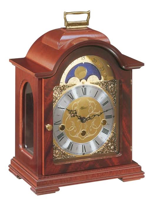 Orologio da tavolo in mogano con quadrante rotondo e cornice decorata, frontale chiuso
