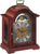 Orologio da tavolo in mogano con quadrante rotondo, cornice ornamentale color oro e fronte protetta