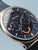 Bering Herrenuhr Nahaufnahme: blaues Zifferblatt mit orangefarbenen Details und Chrono-Subdials