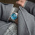 Uhr am Handgelenk mit blauem Zifferblatt und silbernem Metallarmband