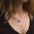 Collana con ciondolo rotondo in legno e catenina sottile in argento indossata sul collo