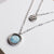 Collana a strati in argento con ciondolo rotondo in madreperla e piccolo charm decorato