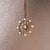 Collana con catena color oro e pendente rotondo con decorazioni