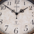 Quadrante dell'orologio da giardino nel dettaglio: tondo beige, numeri neri, ornamenti, logo radio