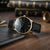 Orologio da uomo Sternglas con cinturino in pelle nera e quadrante nero, bordo cassa color oro