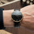 Orologio da uomo Sternglas al polso: cinturino in pelle nera, quadrante nero, bordo color oro