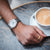 Orologio da uomo Citizen al polso su divano grigio, quadrante cronografo argentato visibile
