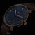 Orologio da uomo in primo piano: quadrante blu, lancette in oro rosa, cinturino in pelle marrone