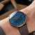 Orologio da uomo al polso: quadrante blu, cinturino in pelle marrone, lunetta in oro rosa