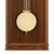 Dettaglio orologio da parete in legno: pendolo rotondo con supporti color oro davanti a una cornice in legno marrone