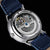 Orologio da uomo automatico con vista aperta sul movimento, cinturino in pelle blu, cassa in acciaio inossidabile