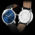 alt
Orologio Naos con quadrante a fasi lunari, dettaglio del movimento meccanico a vista, cinturino in pelle marrone e cassa in acciaio inossidabile lucido.