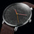 Orologio da uomo frontale: cinturino in pelle marrone, quadrante nero, lancette colorate, data