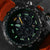 Quadrante di orologio da uomo in dettaglio con indici luminescenti verdi e sottoquadranti del cronografo