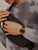 Digitale Vintage-Uhr am Handgelenk mit schwarzem Metallband und goldfarbener Digitalanzeige