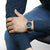 Armbanduhr am Handgelenk mit blauem Zifferblatt und dunkelblauem Armband