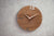 Orologio da parete rotondo in noce con lancette bianche e linee d'accento rosse, numeri