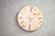 Orologio da parete in legno con design rotondo, numeri 12/6 e lancette rosse