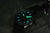 Orologio da uomo scuro con indici blu e verdi luminosi in condizioni di scarsa illuminazione