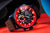 Herrenarmbanduhr mit roter Lünette und schwarzem Zifferblatt, braunes Lederband