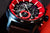 Herrenarmbanduhr Nahansicht: blaues Gehäuse, rotes Zifferblatt, braunes Lederband