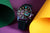 Herrenarmbanduhr mit dunkelbraunem Lederband und rundem Zifferblatt in bunten Farben