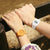 Uhr mit orangefarbenem Armband und Ziffern-Display am Handgelenk