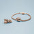 Charm in acciaio inossidabile color oro rosa su bracciale intrecciato con dettagli a cuore