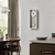 Wanduhr an der Wand mit silbernem Aluminiumrahmen und rundem Pendelgewicht