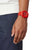 Orologio da uomo con cinturino in caucciù rosso e quadrante rosso, indossato lateralmente al polso.