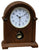 Orologio da tavolo in legno con quadrante rotondo e foro per la carica; cassa marrone, base di supporto.