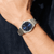 Herrenarmbanduhr am Handgelenk: blaues Zifferblatt, silbernes Metallarmband.