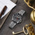 Seiko Herrenuhr auf Unterlage: silbernes Edelstahlarmband, schwarzes Zifferblatt mit GMT