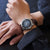 Orologio da uomo al polso con quadrante blu e cinturino in pelle marrone