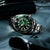Orologio da uomo visibile lateralmente con quadrante verde, lunetta nera, acciaio inossidabile