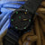 Orologio con quadrante nero, indici luminescenti verdi, lancetta gialla e data
